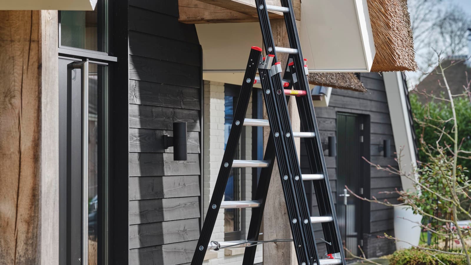 Driedelige reformladder als trap met uitgeschoven derde deel bij een woning