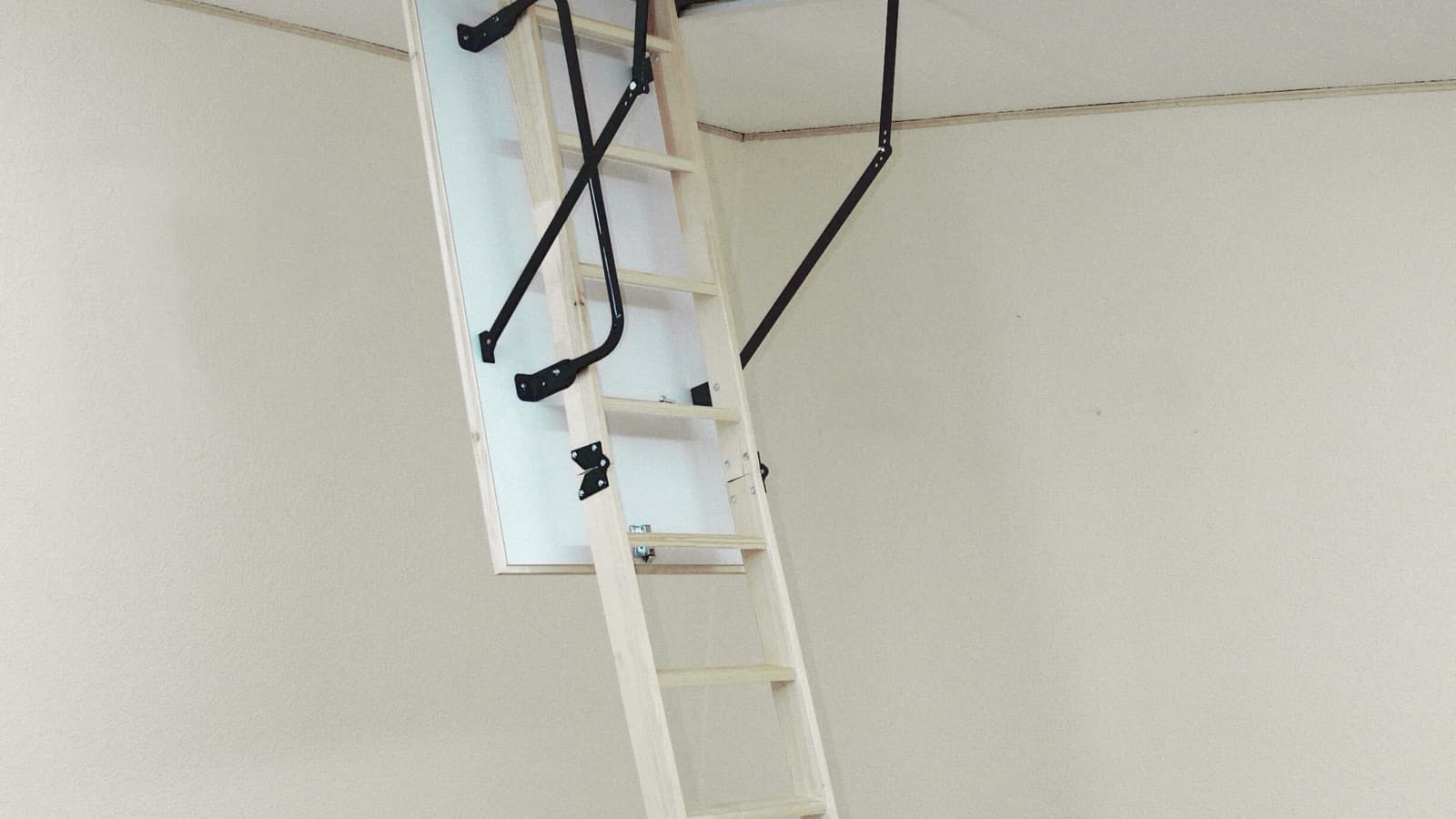 Escalier escamotable en bois déplié depuis une trappe de plafond